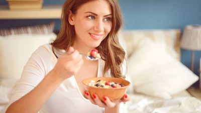 2020/07/woman-in-pajamas-in-bedroom-eating-muesli-with-royalty-free-image-525343946-1566830366.jpg