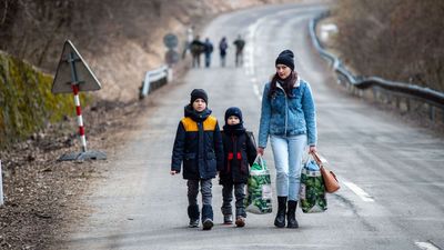 2022/03/woman-with-two-children-and-carrying-bags-walk-on-a-street-news-photo-1646060392-scaled.jpg