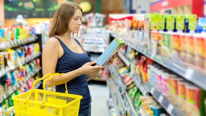 2022/09/woman-checks-label-shopping-supermarket-grocery-store-aisle_iStock-524289987.jpg