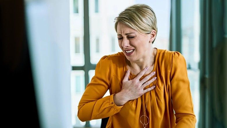 2022/10/woman-chest-pain-heart-attack-office.jpg