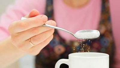2023/12/woman-putting-sugar-in-tea-coffee.jpg
