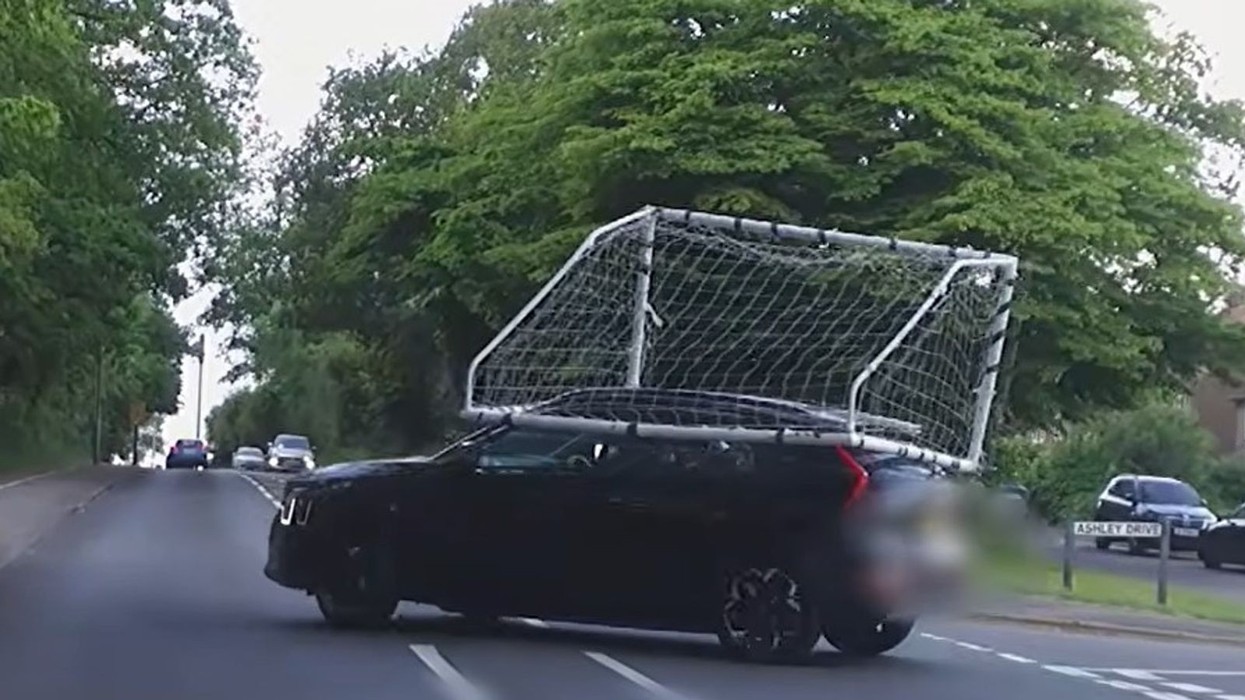 Shoferi britanik filmohet me portë futbolli sipër makinës