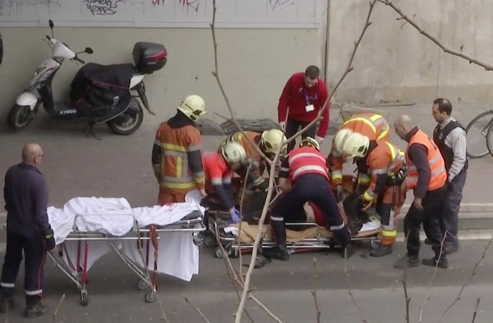 In this image made from video, emergency rescue workers stretcher an unidentified person at the site of an explosion at a metro station in Brussels, Belgium, March 22, 2016. Explosions rocked the Brussels airport and the subway system Tuesday, just days after the main suspect in the November Paris attacks was arrested in the city, police said.(APTN via AP)