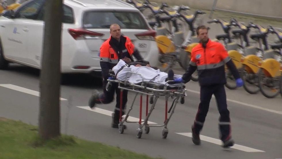 In this image taken from TV an injured person is evacuated as emergency services attend the scene after an explosion in a main metro station in Brussels on Tuesday, March 22, 2016. Explosions rocked the Brussels airport and the subway system Tuesday, killing a number of people and injuring many others just days after the main suspect in the November Paris attacks was arrested in the city, police said. (AP Photo)
