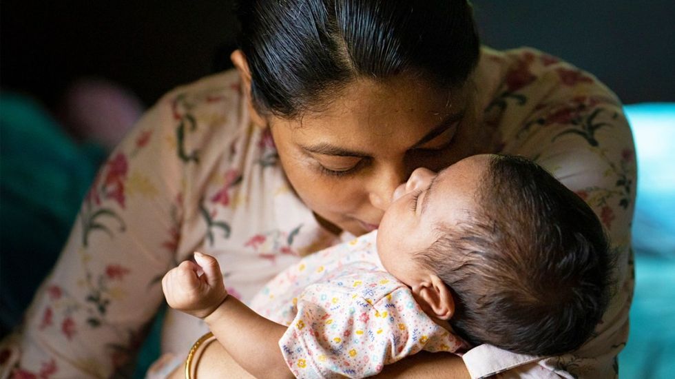 indian mother smelline newborn baby header