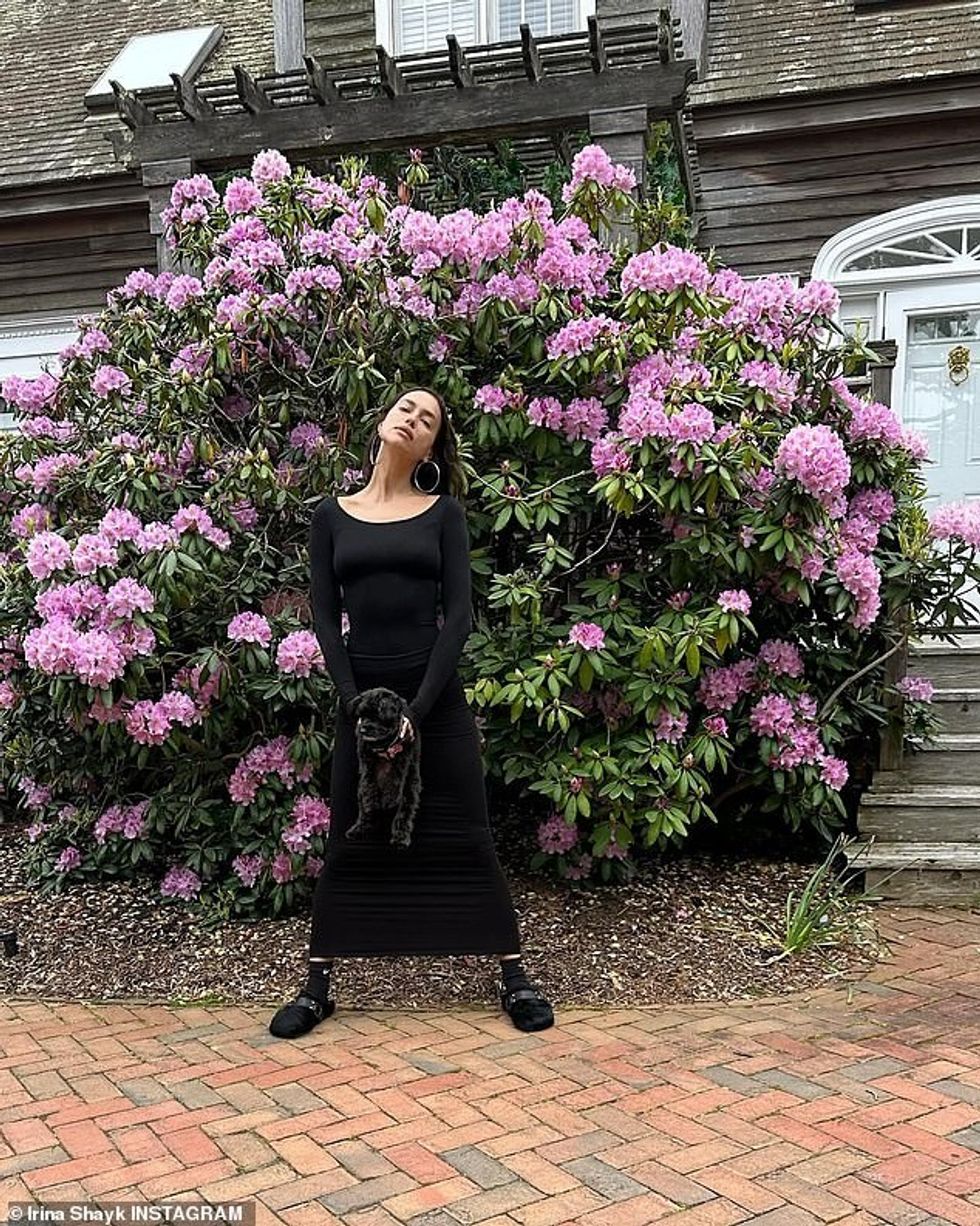 Irina pozoi gjithashtu para një kaçubeje të madhe lulesh vjollce në një tjetër foto argëtuese