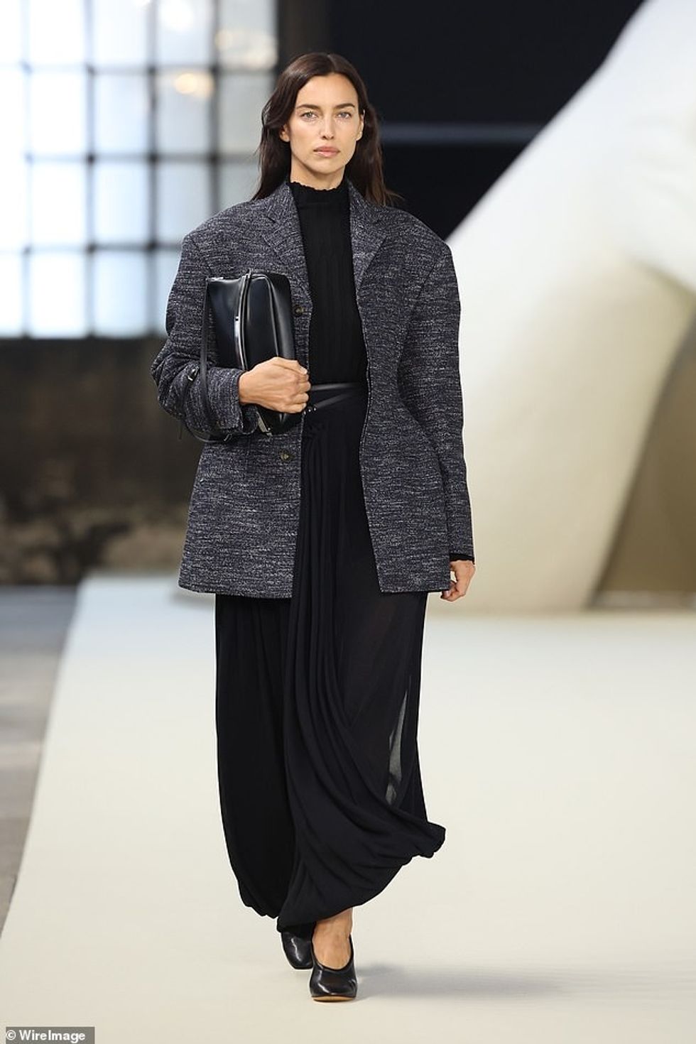 Irina Shayk, 38, e cila iu bashkua Naomit në pistë, theksoi belin e saj me një fustan maxi të zi të mbledhur të cilit i shtoi një rrip të hollë të zi.