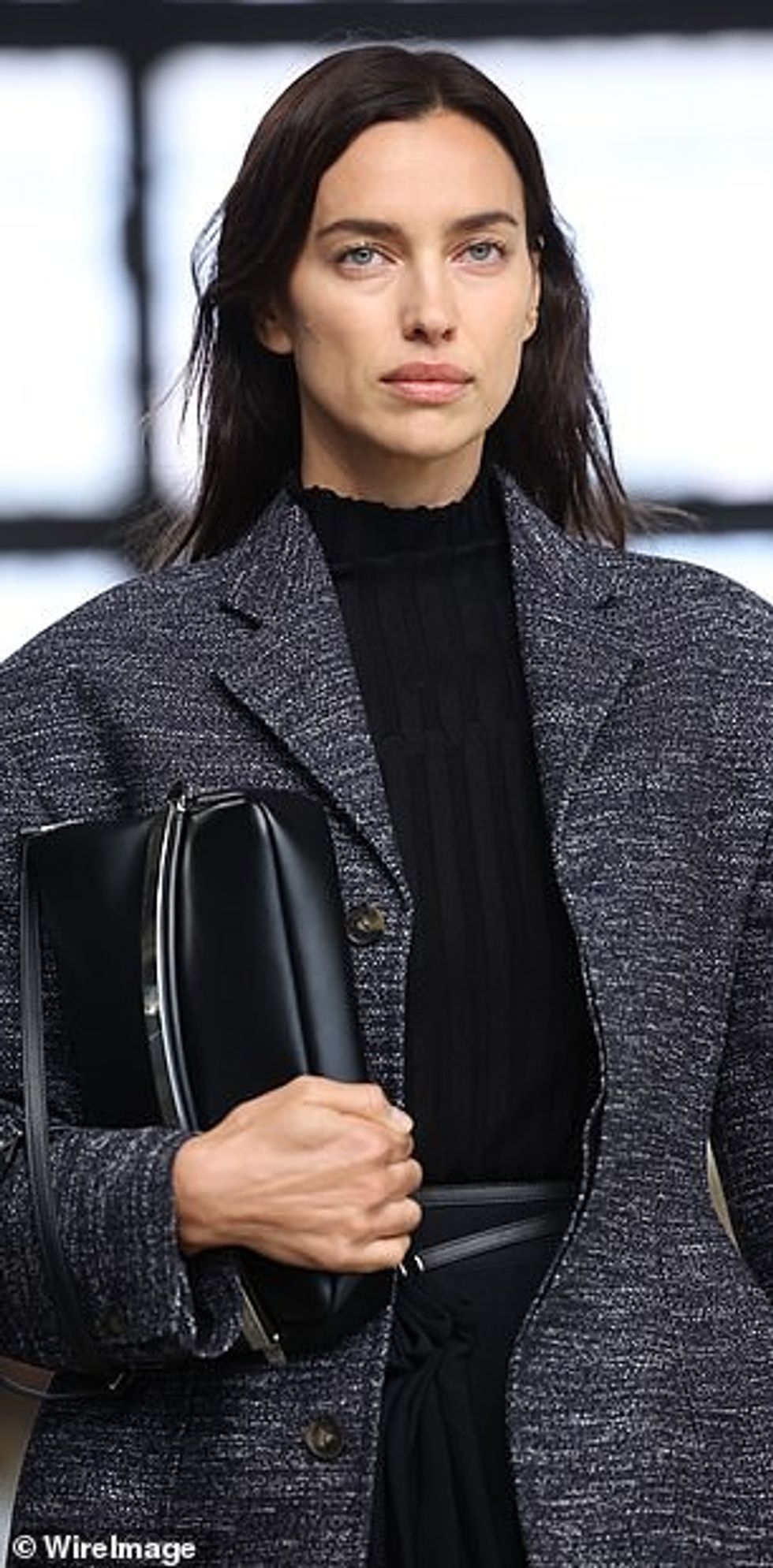 Irina veshi me një pallto merlo leshi gri dhe një çantë lëkure të zezë në pistë.