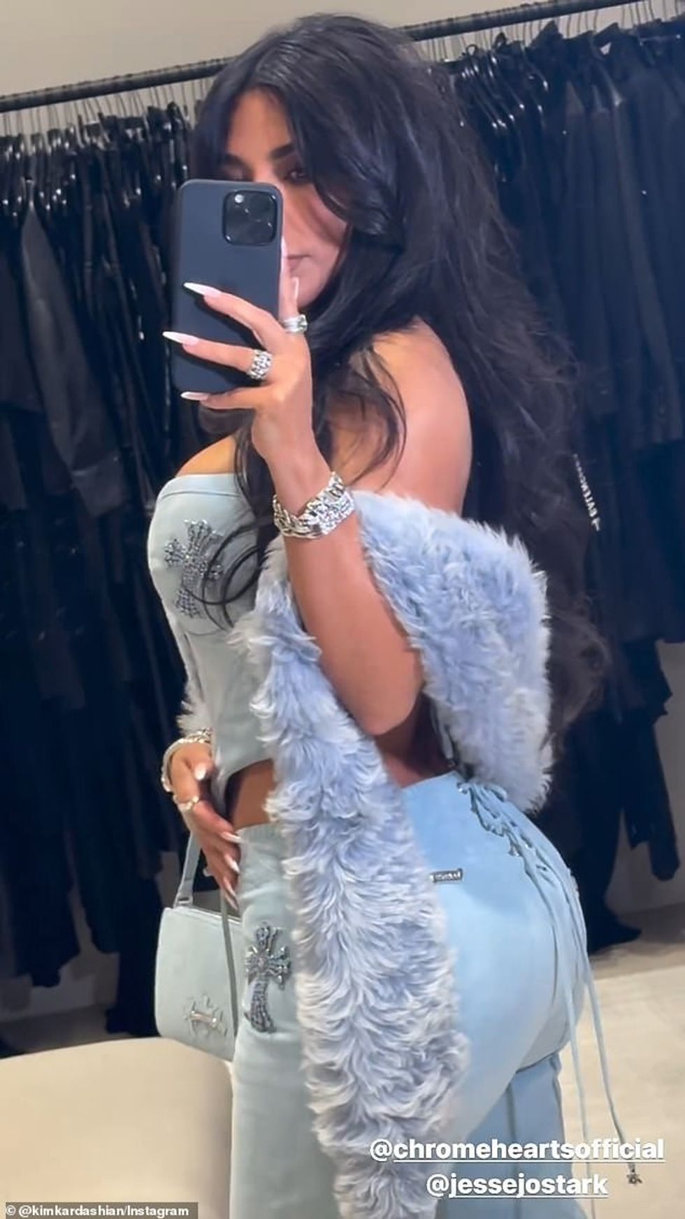 Kim e shtroi ansamblin me një shall të turbullt, blu që i shtrinte krahët drejt bërrylave dhe mbante një çantë blu në dorë.