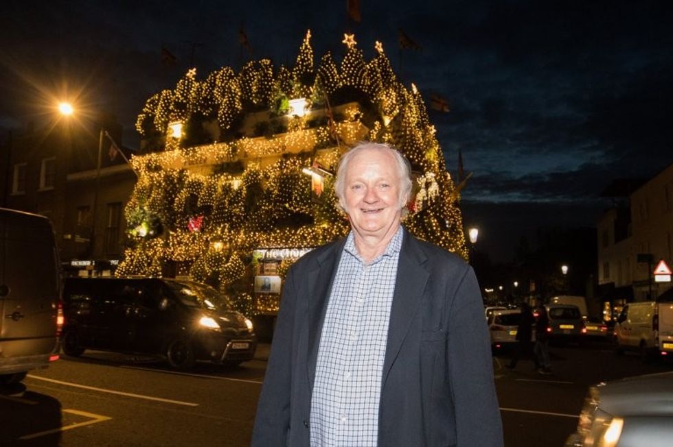 Landlord Gerry O'Brien, 65, outside of The Churchill Arms, London. 07 December 2016. The tree is decorated with 85 trees and 20,000 lights which took a week and a half to put in place. The famous pub, near to Notting Hill Gate, has useflowers and plants all year round attract punters for nearly 30 years.