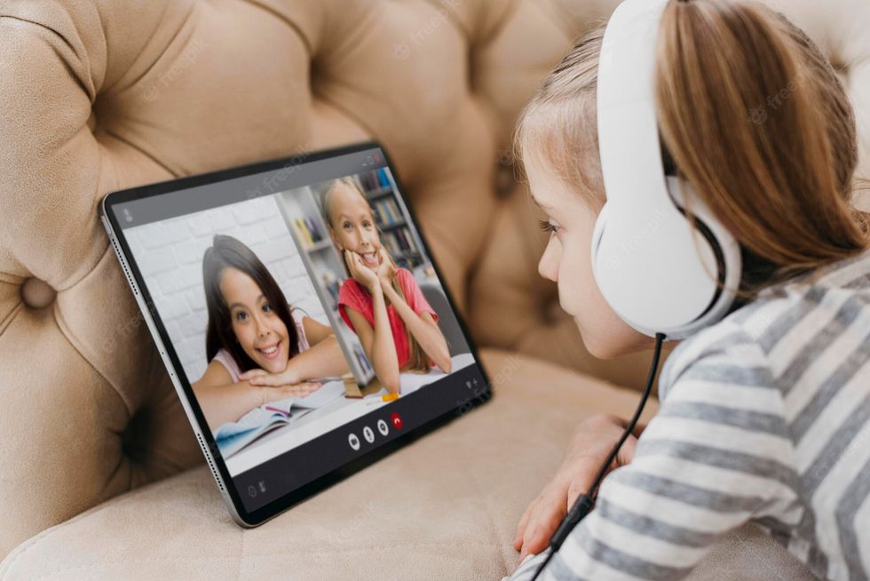 little girl talking her friends laptop video call 23 2148982452