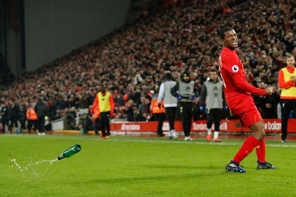 Liverpools Georginio Wijnaldum celebrates scoring their first goal as a bottle is thrown onto the p