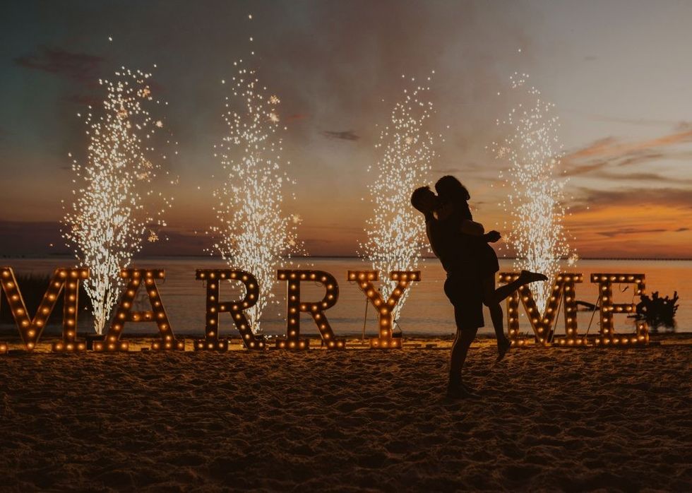 magical sunset beach proposal with marquee letters and sparklers 1