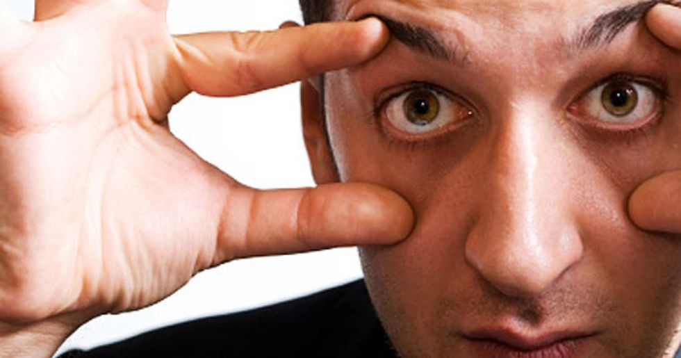 man holding eyes open