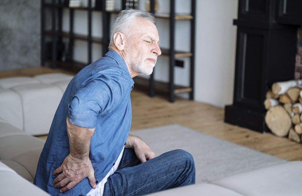 man holding his back experiencing winter joint pain
