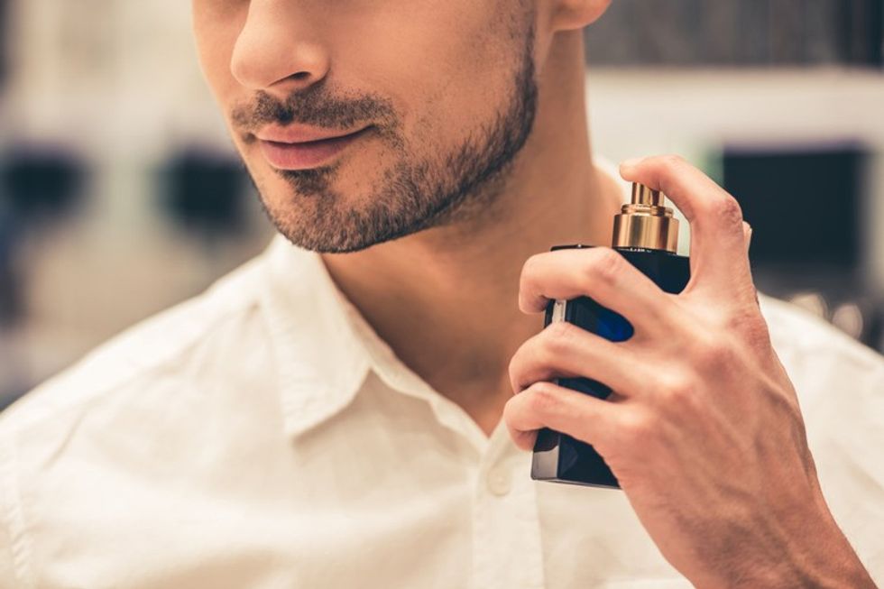 man putting on perfume