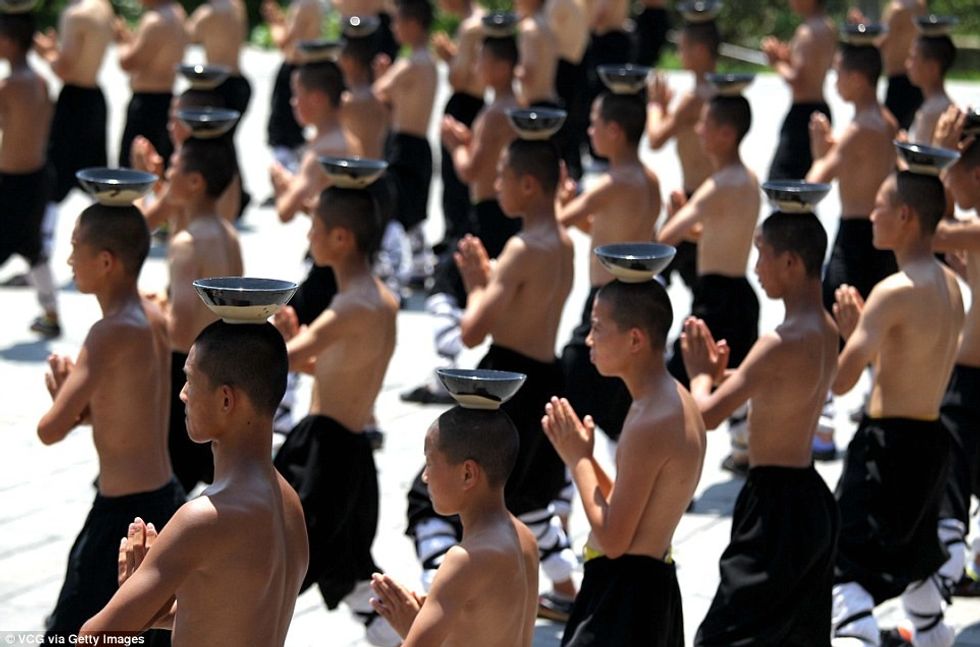 Meditimi nën diellin përcëllues duke mbajtur nje pjate me uje ne koke foto 6