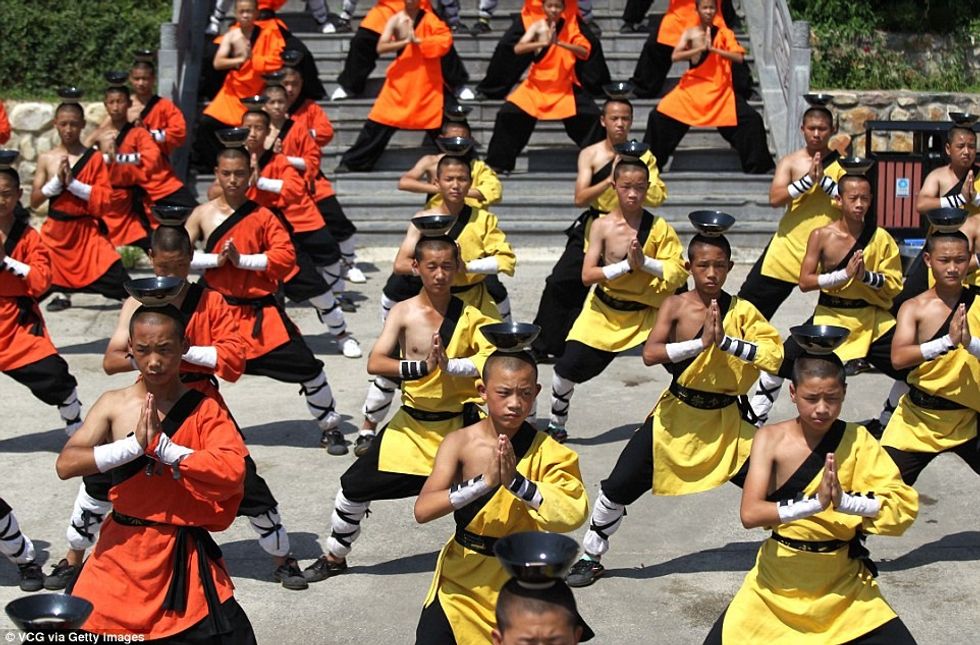 Meditimi nën diellin përcëllues duke mbajtur nje pjate me uje ne koke foto 9