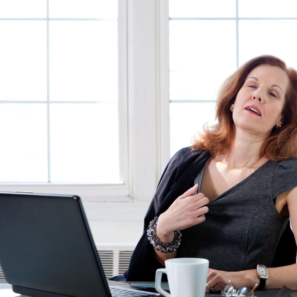 menopausal woman having a hot flash at the office 183801605 5a982244fa6bcc003768d56e