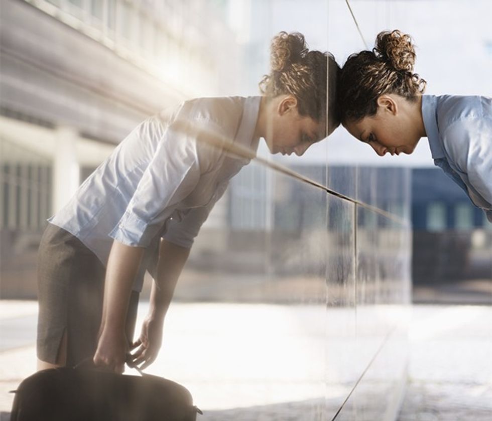 mid adult italian business woman banging her head against a wall outside office building. Square shape, copy space