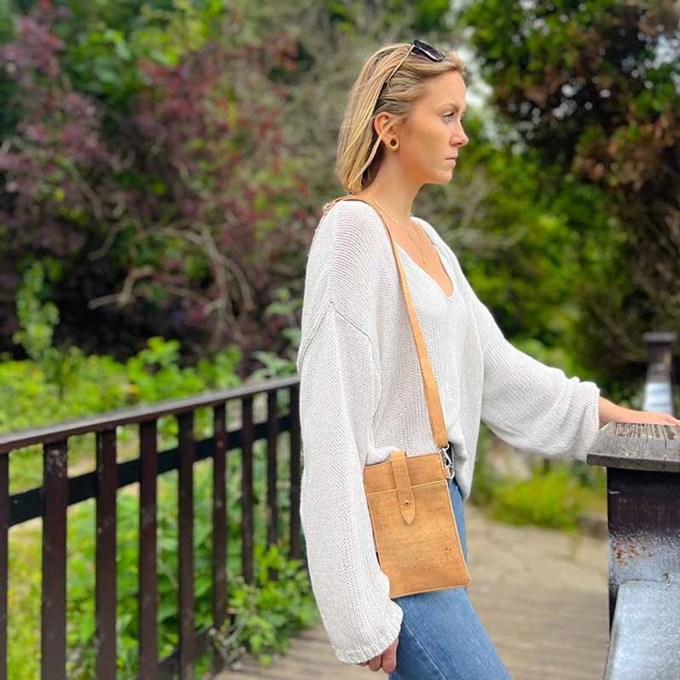model carrying a natural cork crossbody phone bag