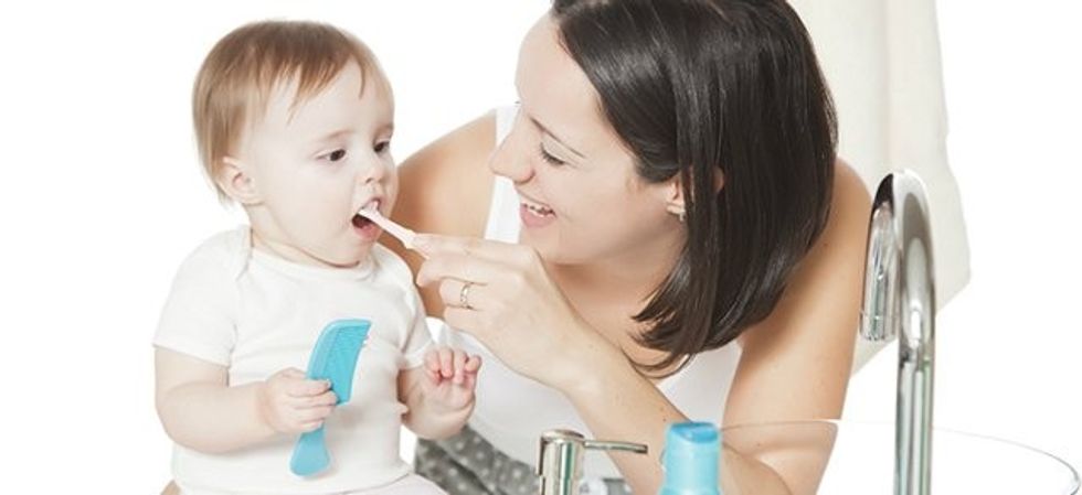 mom brushing baby teeth2