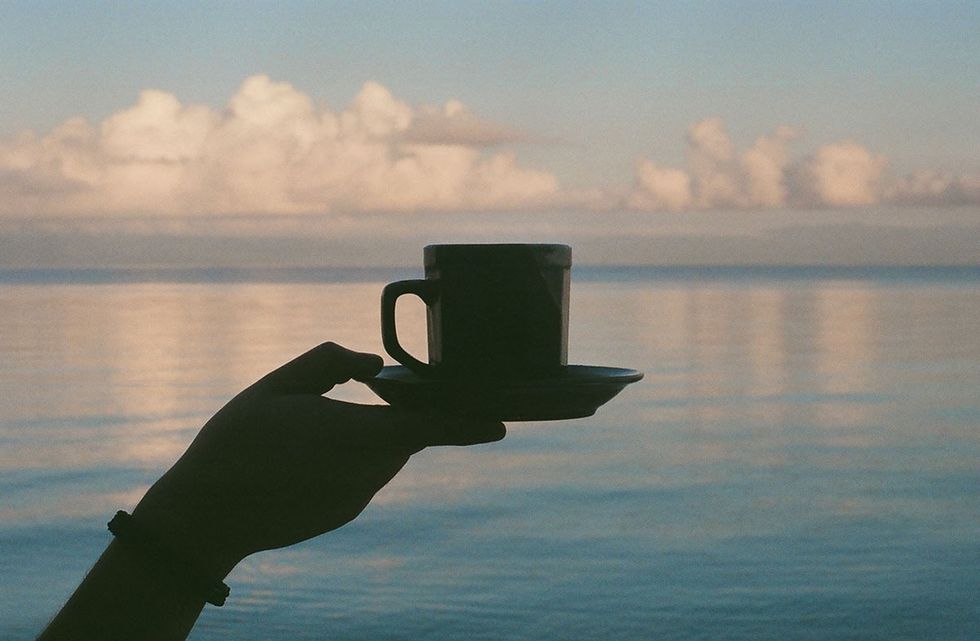 morning coffee hand holding coffee and saucer at sea