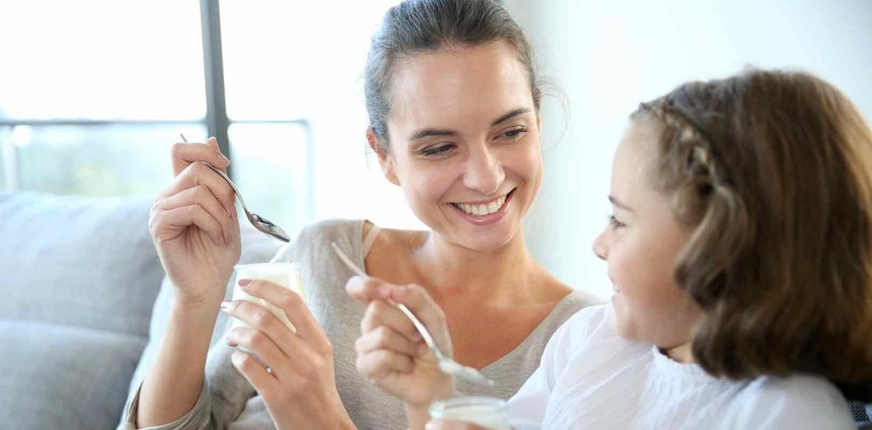 Mother and daughter eating yoghurt