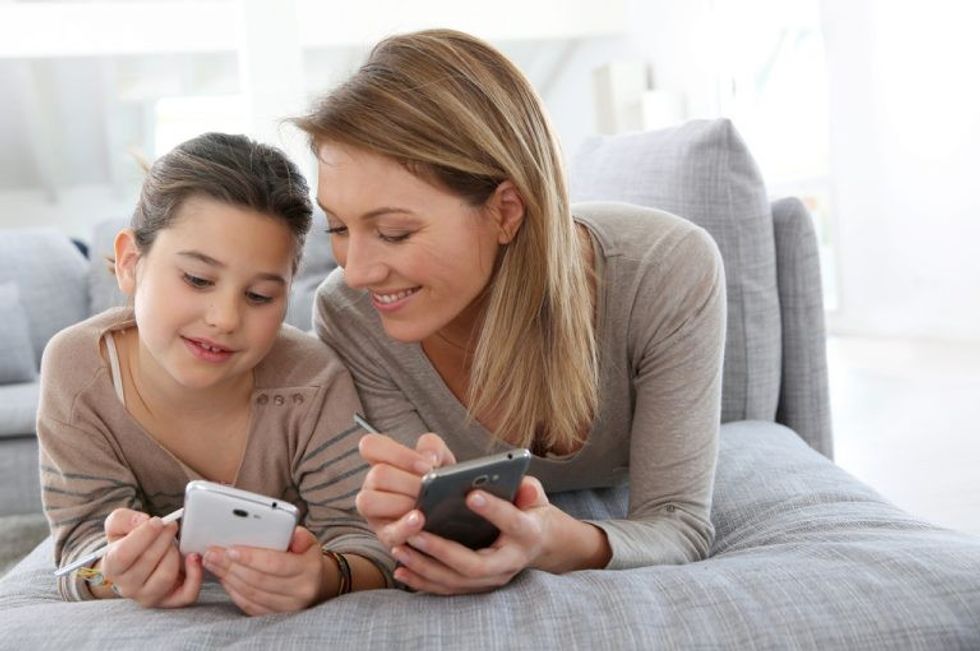 mother and daughter using smartphones 1