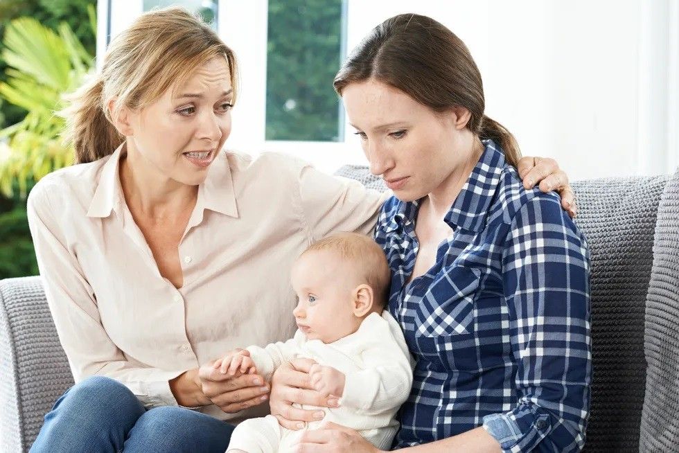 mother comforting adult daughter suffering with postpartum