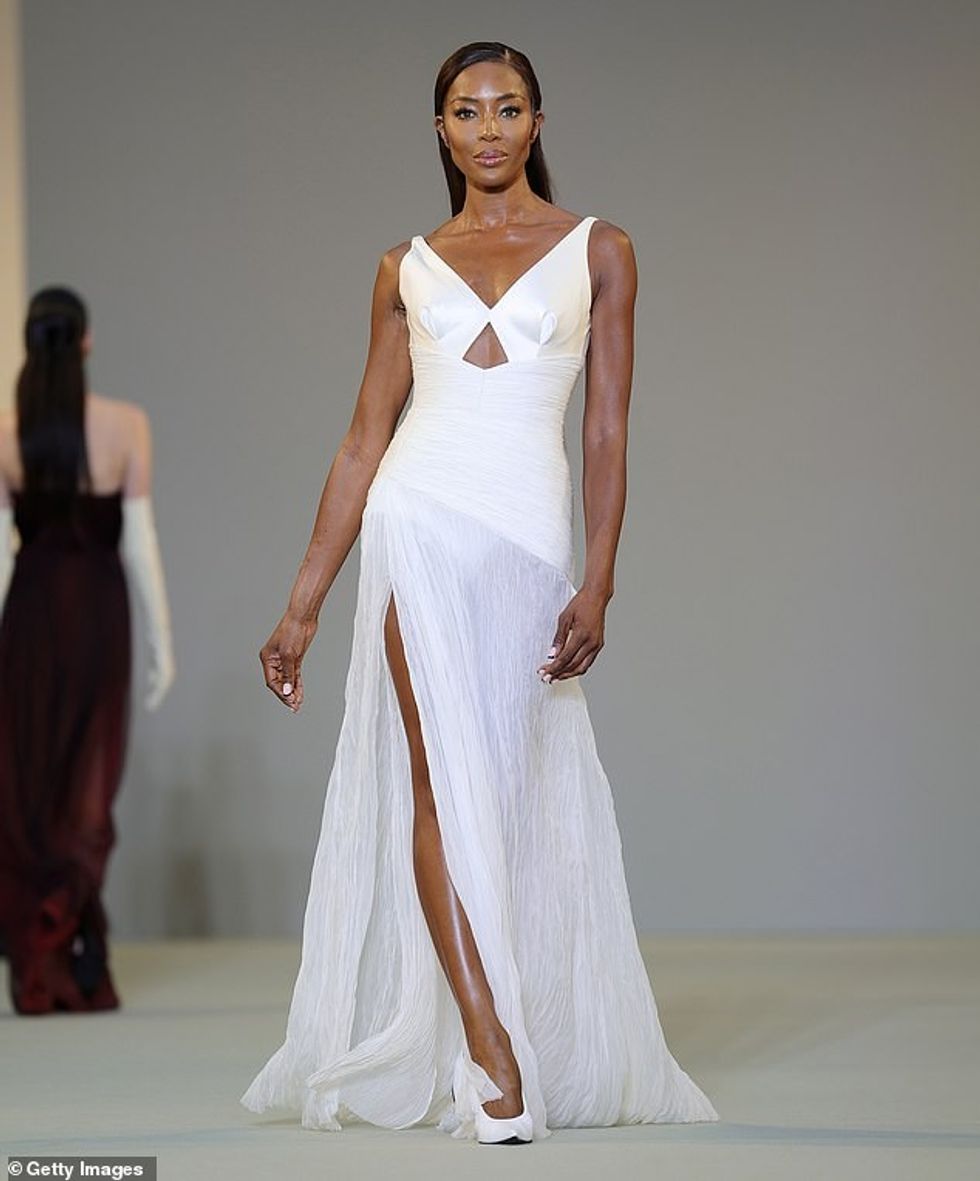 Naomi Campbell dukej e pabesueshme teksa modelonte një fustan të bardhë teksa hapte sfilatën e Del Core gjatë javës së modës në Milano të mërkurën.