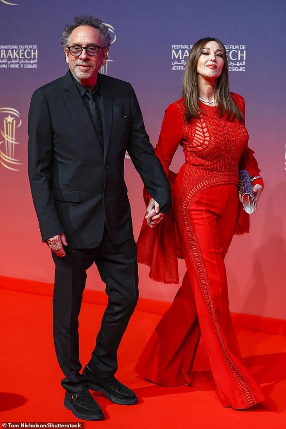 Ndërkohë, partneri i saj Tim dukej tepër i lagësht me një kostum të zi me tre pjesë, i përbërë nga një xhaketë sportive e zezë me një gji, një këmishë e zezë e kontrolluar dhe pantallona të qepura.