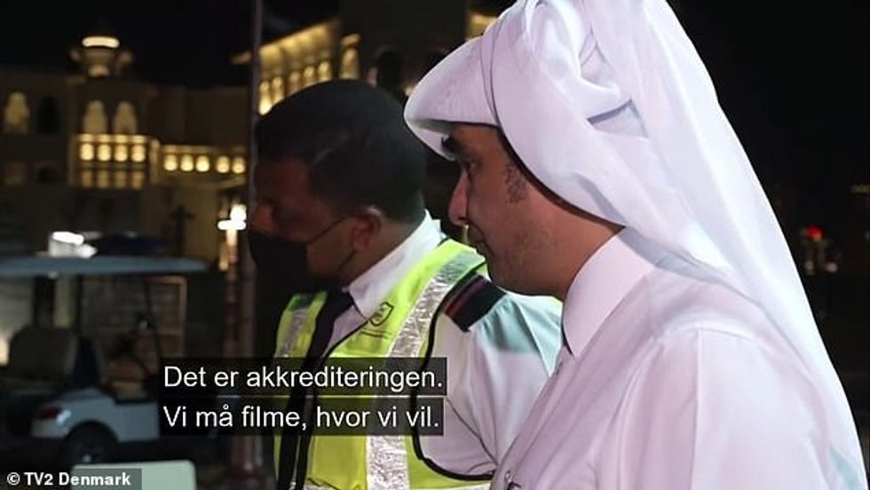 Një roje sigurie përpiqet të shpjegojë se ai nuk është në gjendje të filmojë, pavarësisht lejes së akreditimit