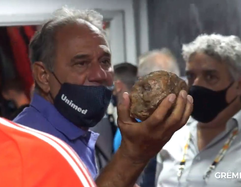 Officials held up a huge stone which was thrown at the bus during the cowardly attack