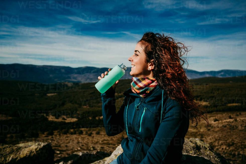 optimistic woman smiling and drinking w