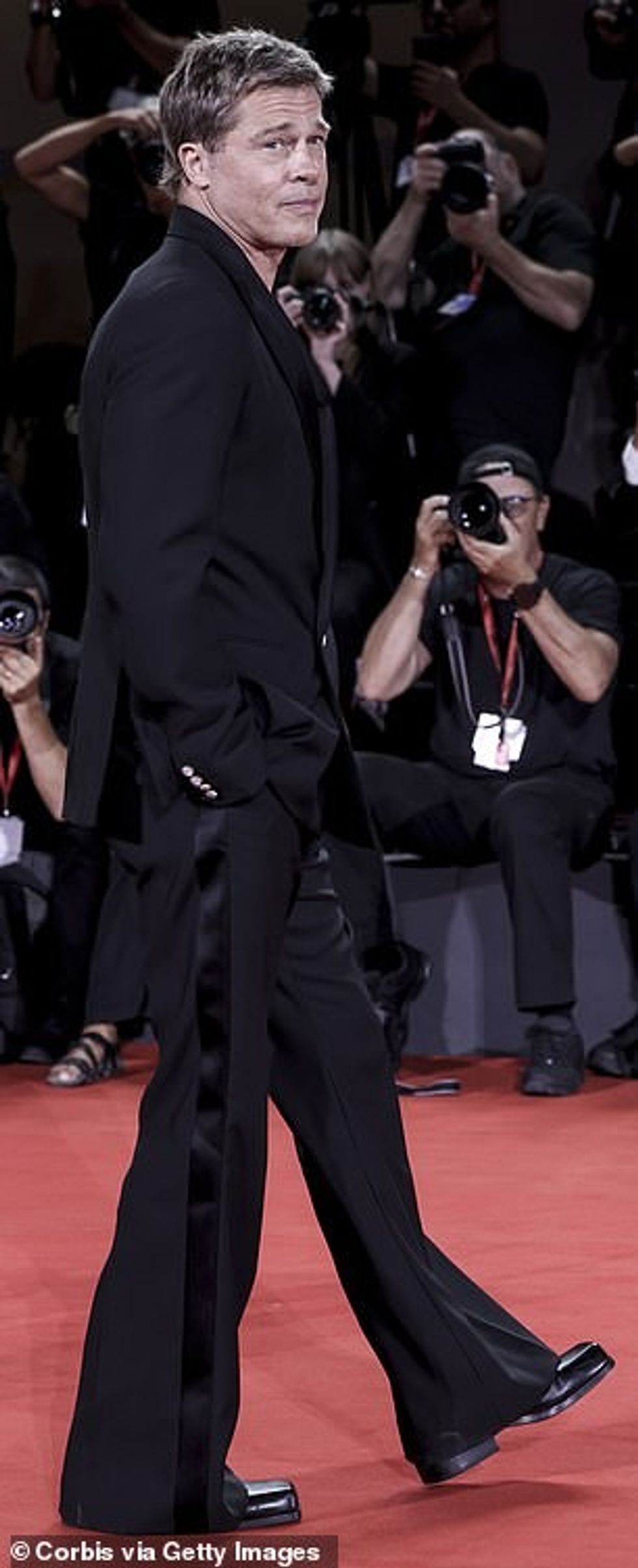 Pantallonat e tij të ndezura ishin gjithashtu pikë për të folur ndërsa zvarriteshin përgjatë dyshemesë, aq sa për të lënë çizmet e tij të zeza me platformë të dalin nga poshtë