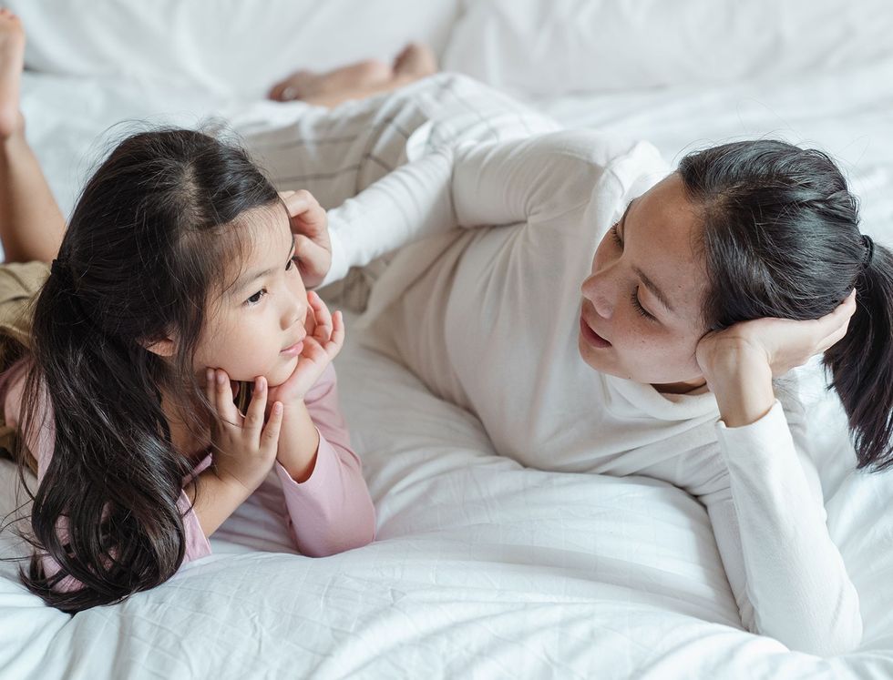 parents and racism photo of woman and girl talking while lying on bed 4473774 2