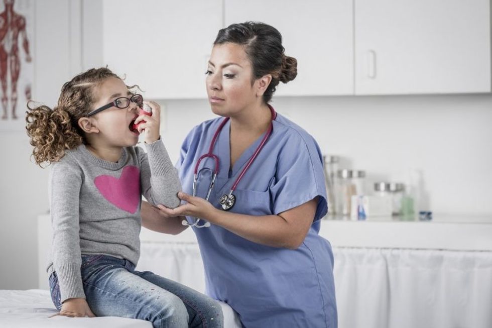 pediatrician showing girl inhaler in examination room 536907305 597113719abed50011f4af40