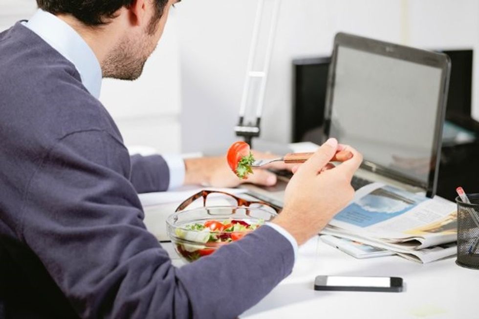 person eating at his desk at work body resized