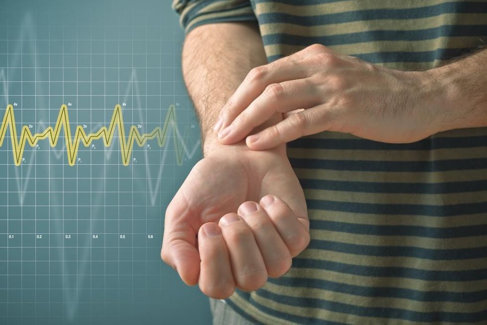 person lowering their heart rate with fingers on wrist to measure pulse