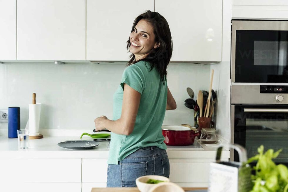 portrait of smiling woman cooking in kitchen ERRF01713