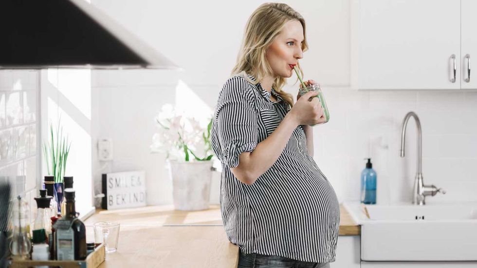pregnant woman drinking green smoothie