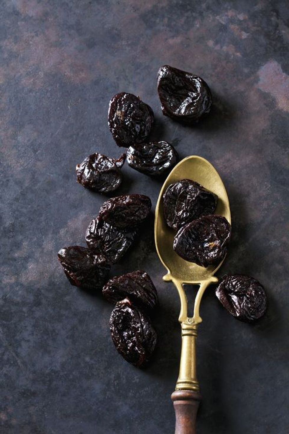 prunes on a vintage brass spoon royalty free image 1611951866