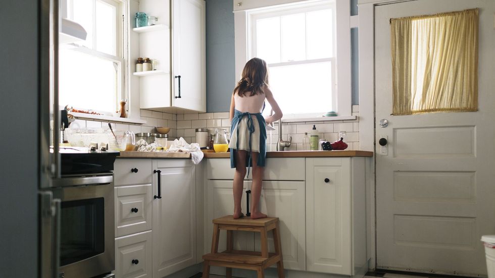 rear view of girl washing dish in kitchen at home 961013398 5bcaa00846e0fb00515b597