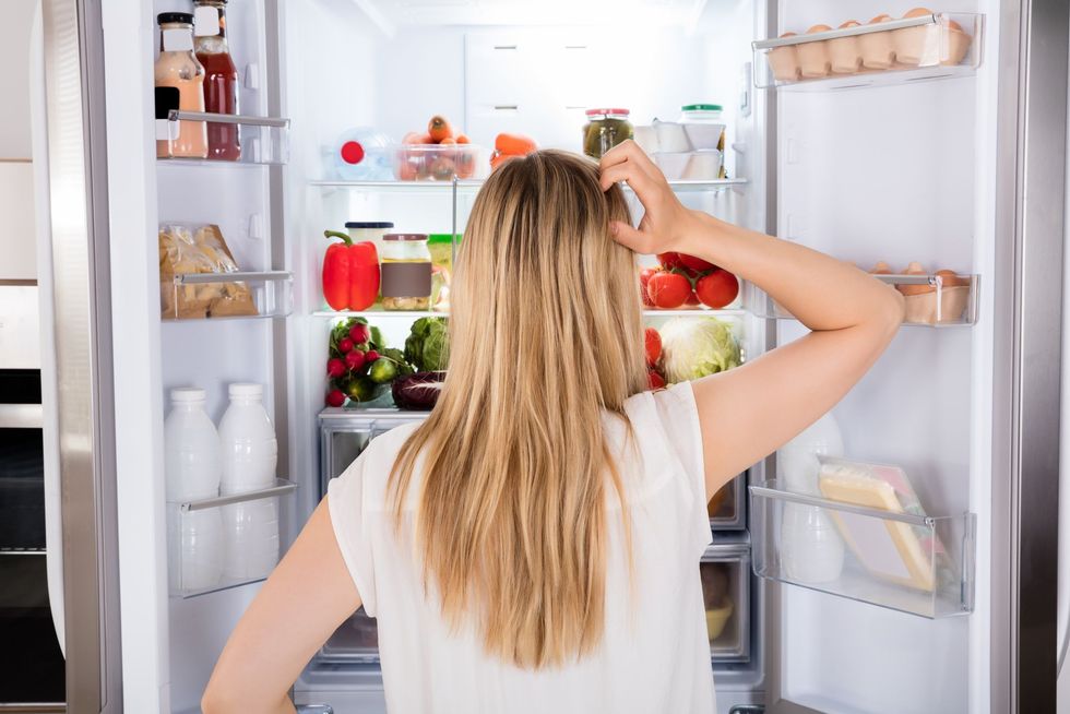 rear view of woman looking in fridge royalty free image 859444676 1559217243