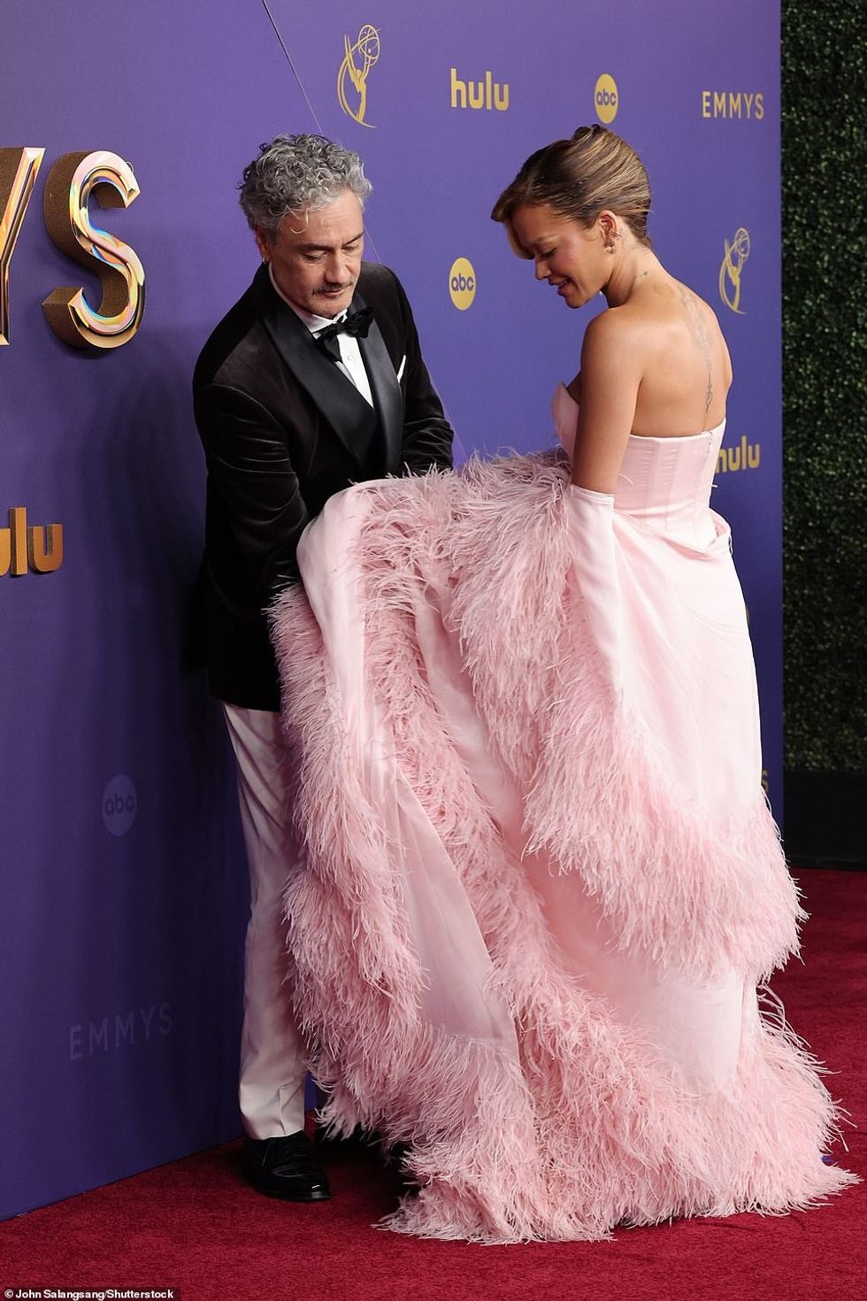 Regjisori i filmit u pa duke ndihmuar gruan e tij të rregullonte fustanin e saj në një moment të ëmbël të kapur në tapetin e kuq