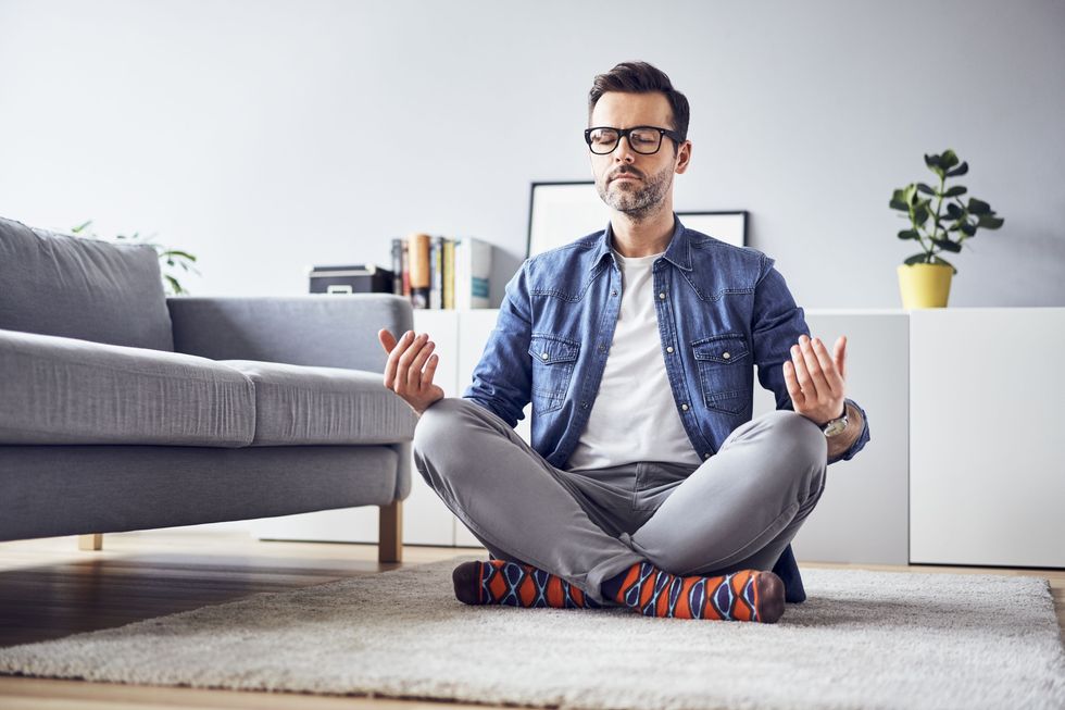 relaxed man meditating at home 946931302 5c16803846e0fb0001a669ae