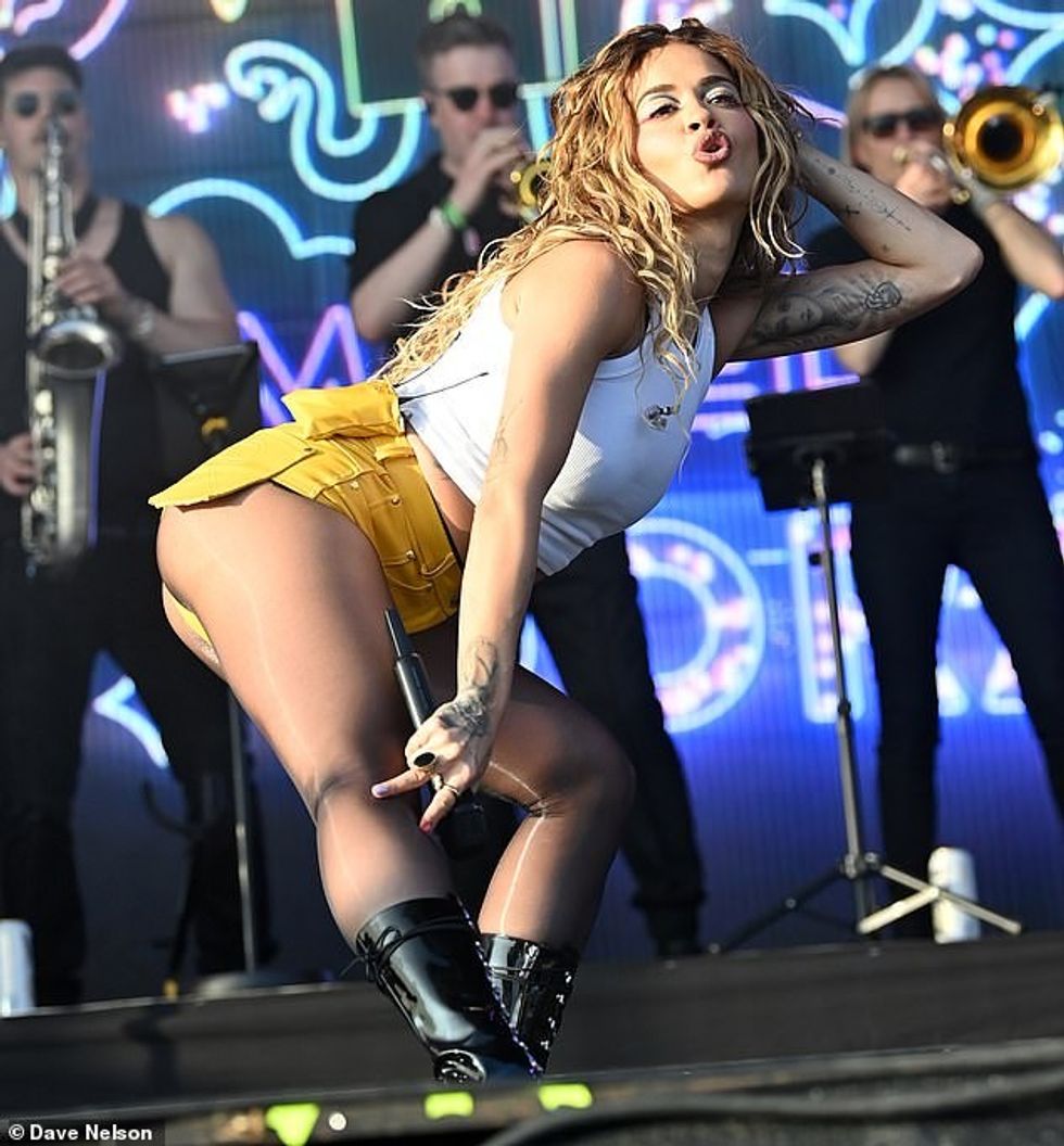 Rita finished her outfit with shiny pair of sheer black tights and below-the-knee shiny punk-style black boots