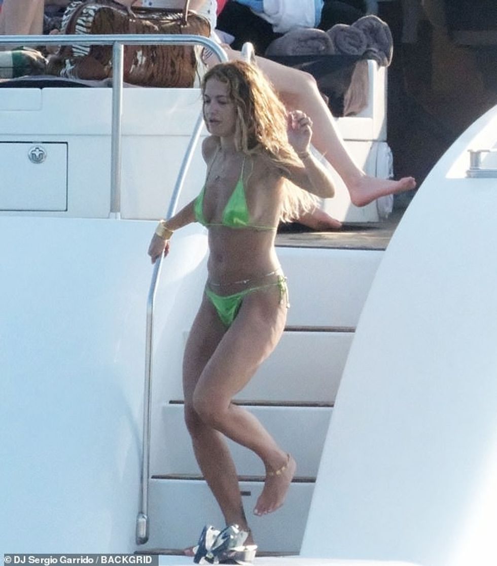 Rita Ora sent temperatures soaring in a skimpy green metallic bikini as she enjoyed a sun-soaked yacht day in Ibiza on Saturday