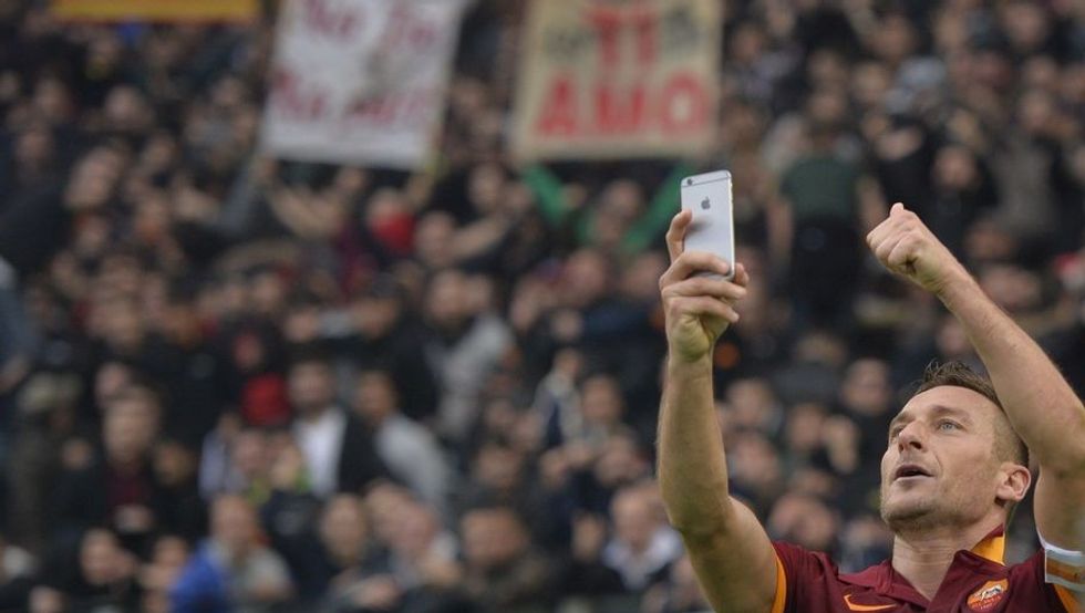 Roma's forward Francesco Totti celebrates by taking a